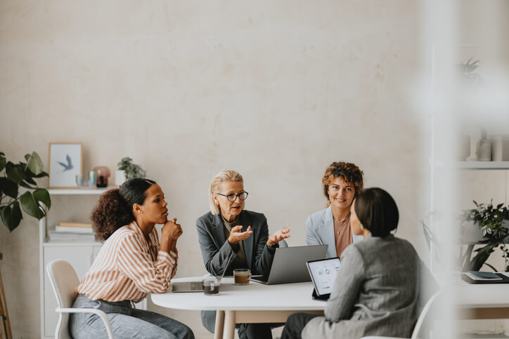 Four women working around a table together.